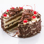 Sliced black forest cake showing the layers of sponge, fresh cream and cheerries